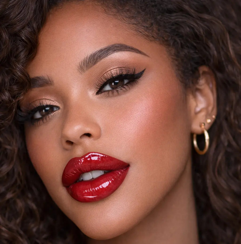Close-up of a woman wearing diamond glow cherry sundae lip gloss with curly hair