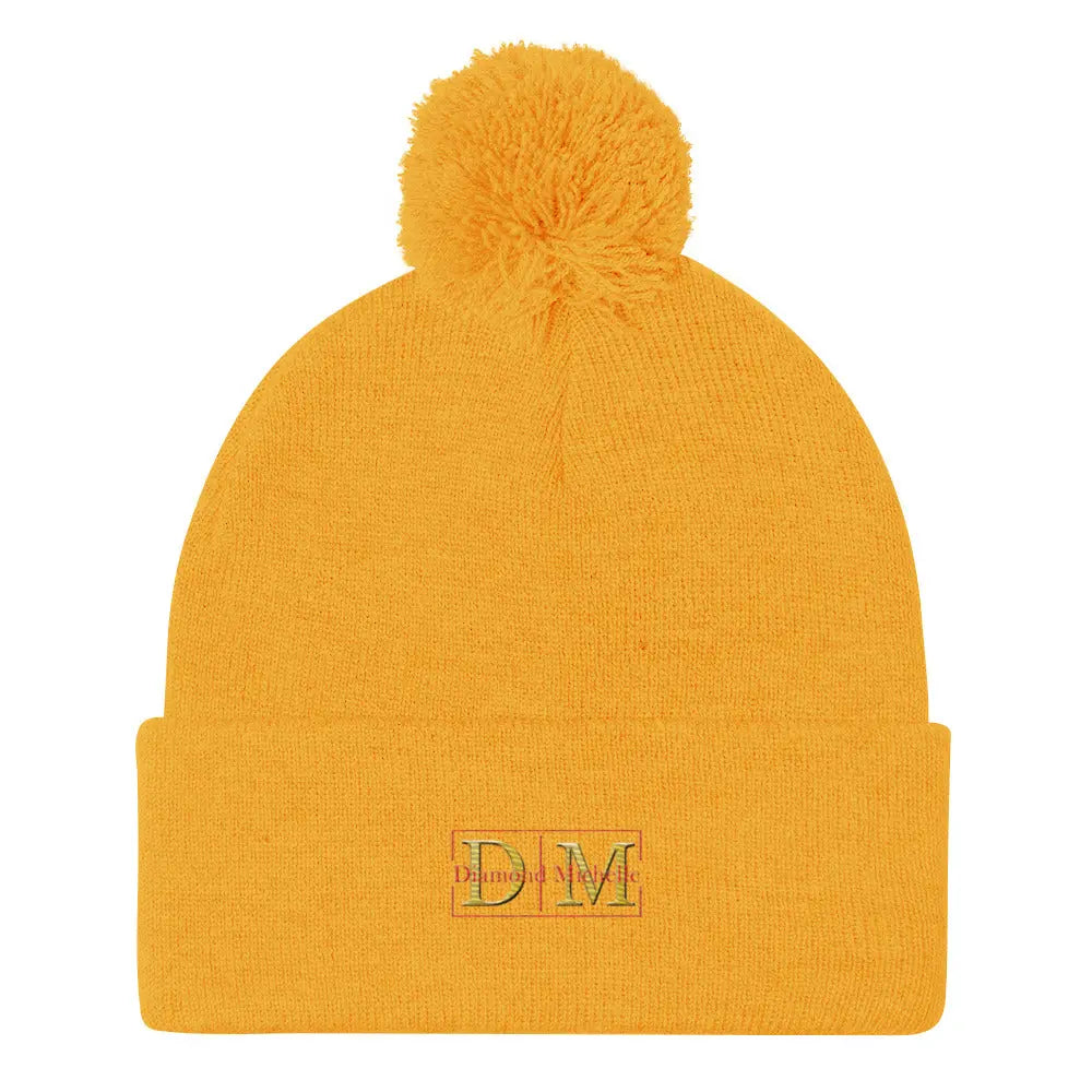 Flat front view of a gold DM Pom-Pom Beanie on a white background