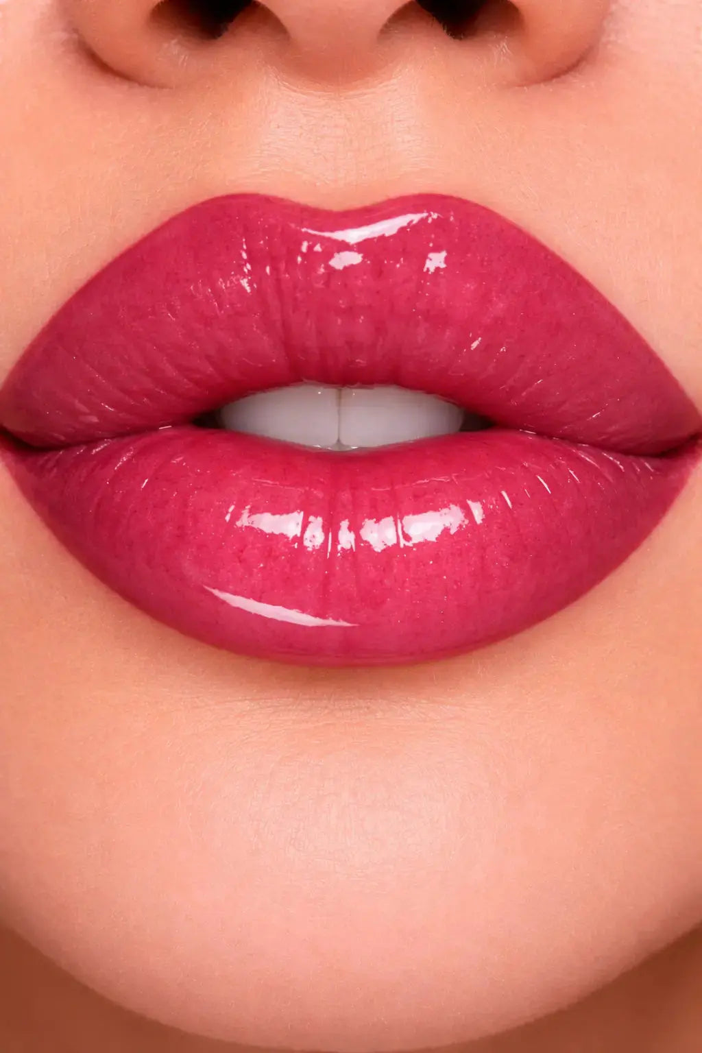 Close-up of glossy fuschia lip gloss on lips
