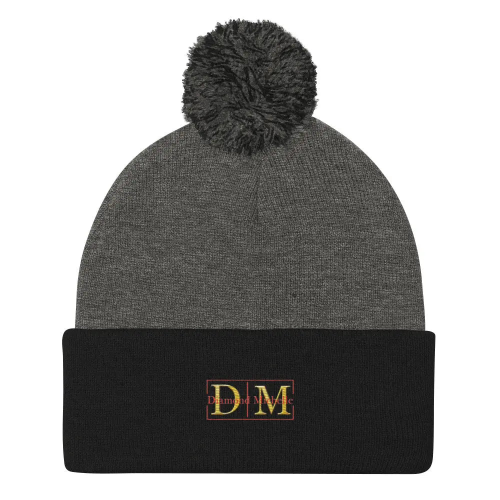 Flat front view of a dark heather and black DM Pom-Pom Beanie on a white background