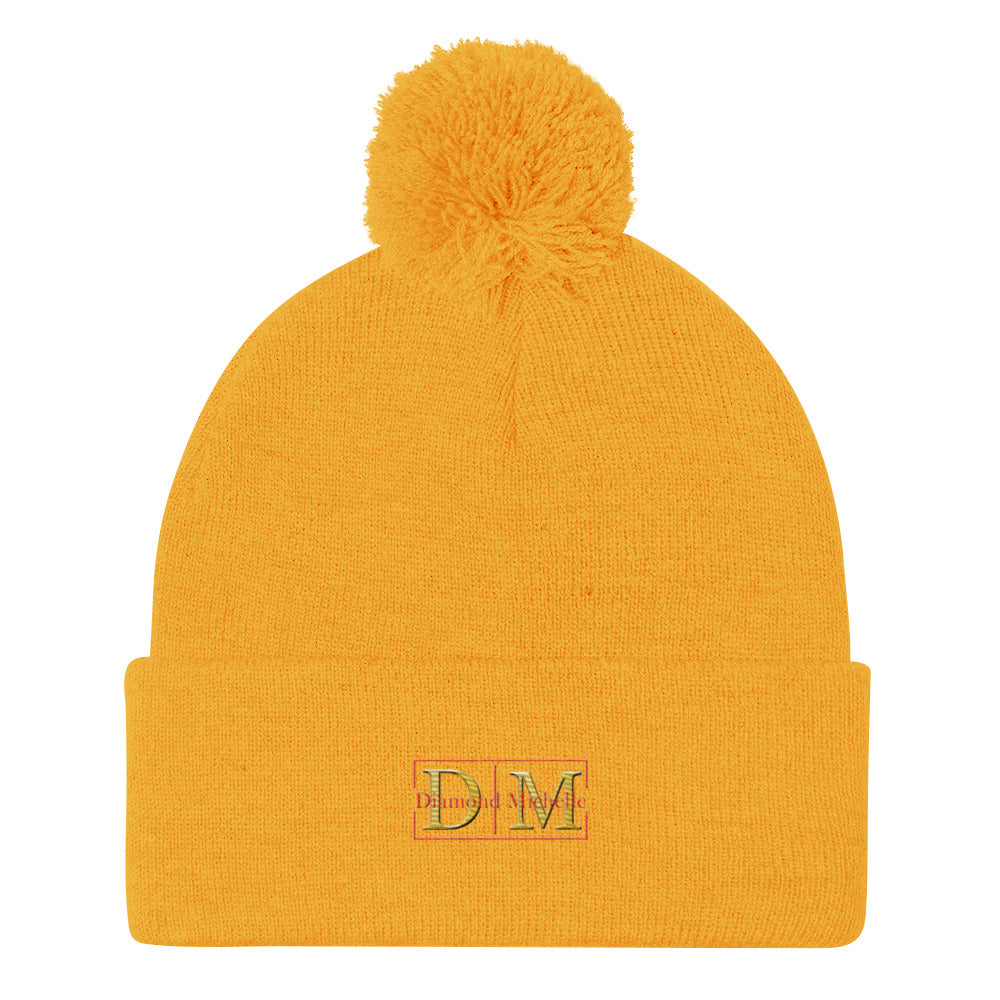 Flat front view of a gold DM Pom-Pom Beanie on a white background