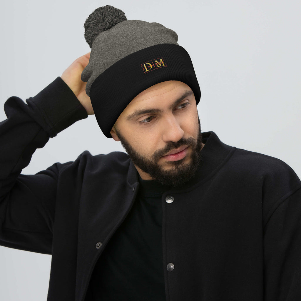 Man wearing a drak heather grey and black DM Pom-Pom Beanie front view