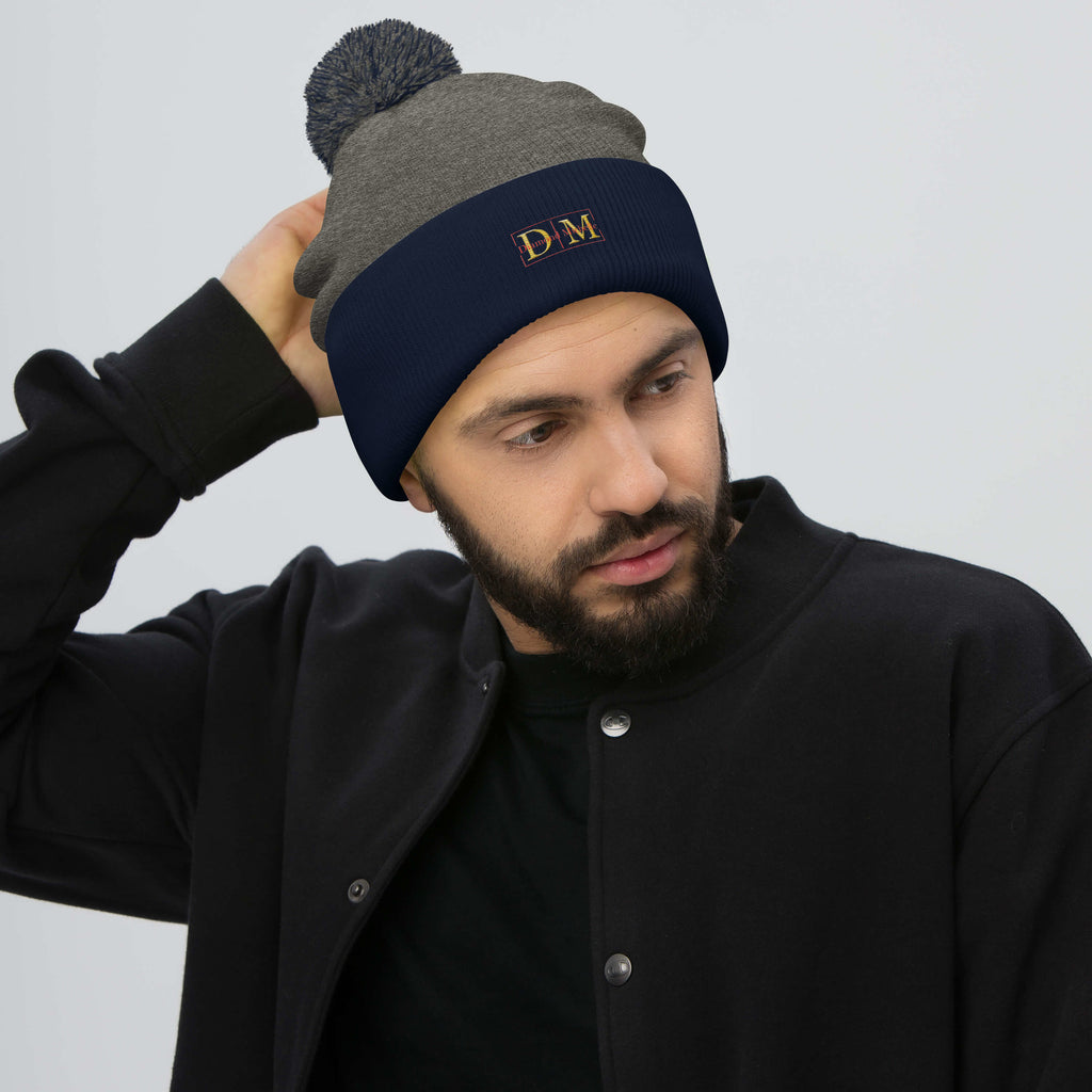 Man wearing a dark heather grey and navy DM Pom-Pom Beanie front view