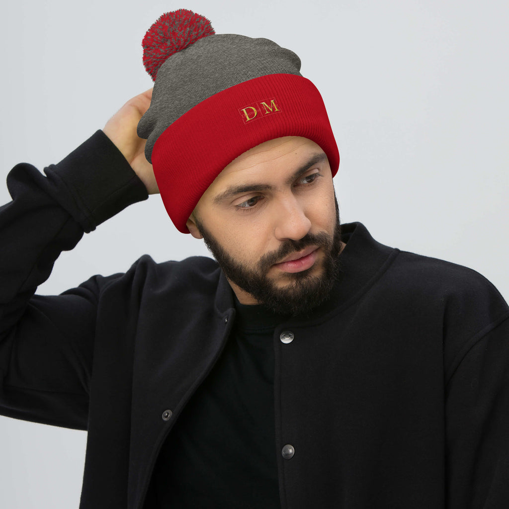 Man wearing a dark heather and red DM Pom-Pom Beanie front view