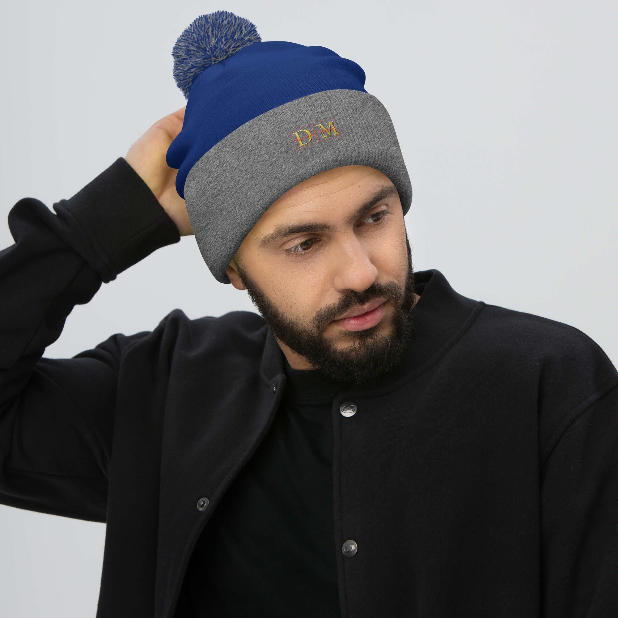 Man wearing a royal blue and heather grey DM Pom-Pom Beanie front view