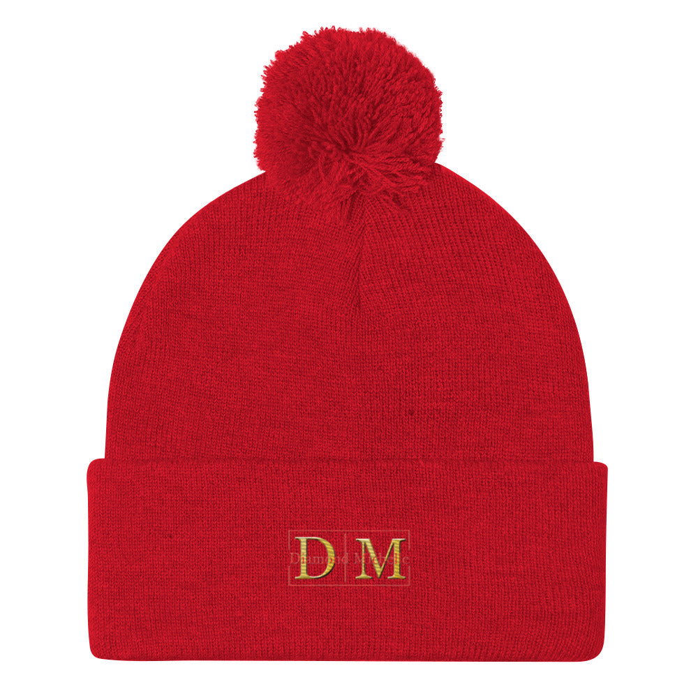Flat front view of a red DM Pom-Pom Beanie on a white background