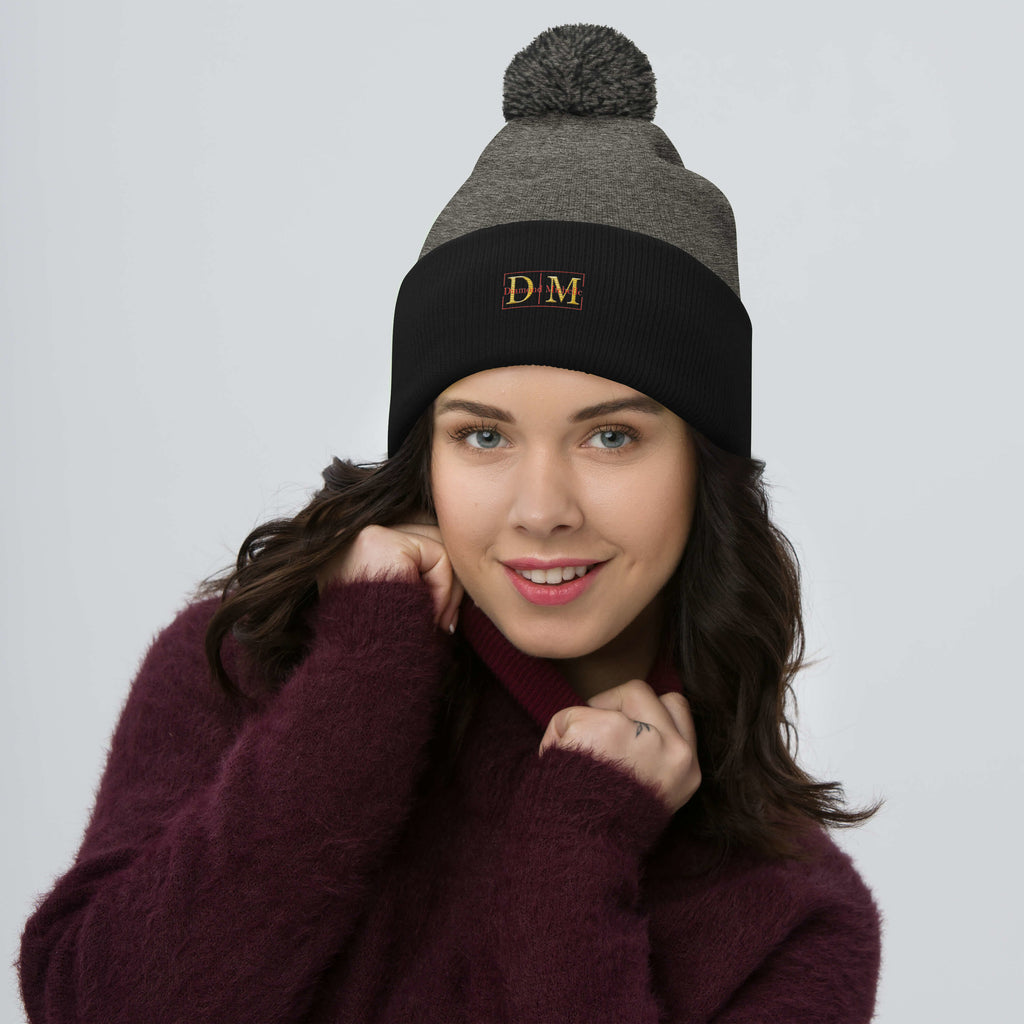Woman wearing a dark heather grey and black DM Pom-Pom Beanie front view