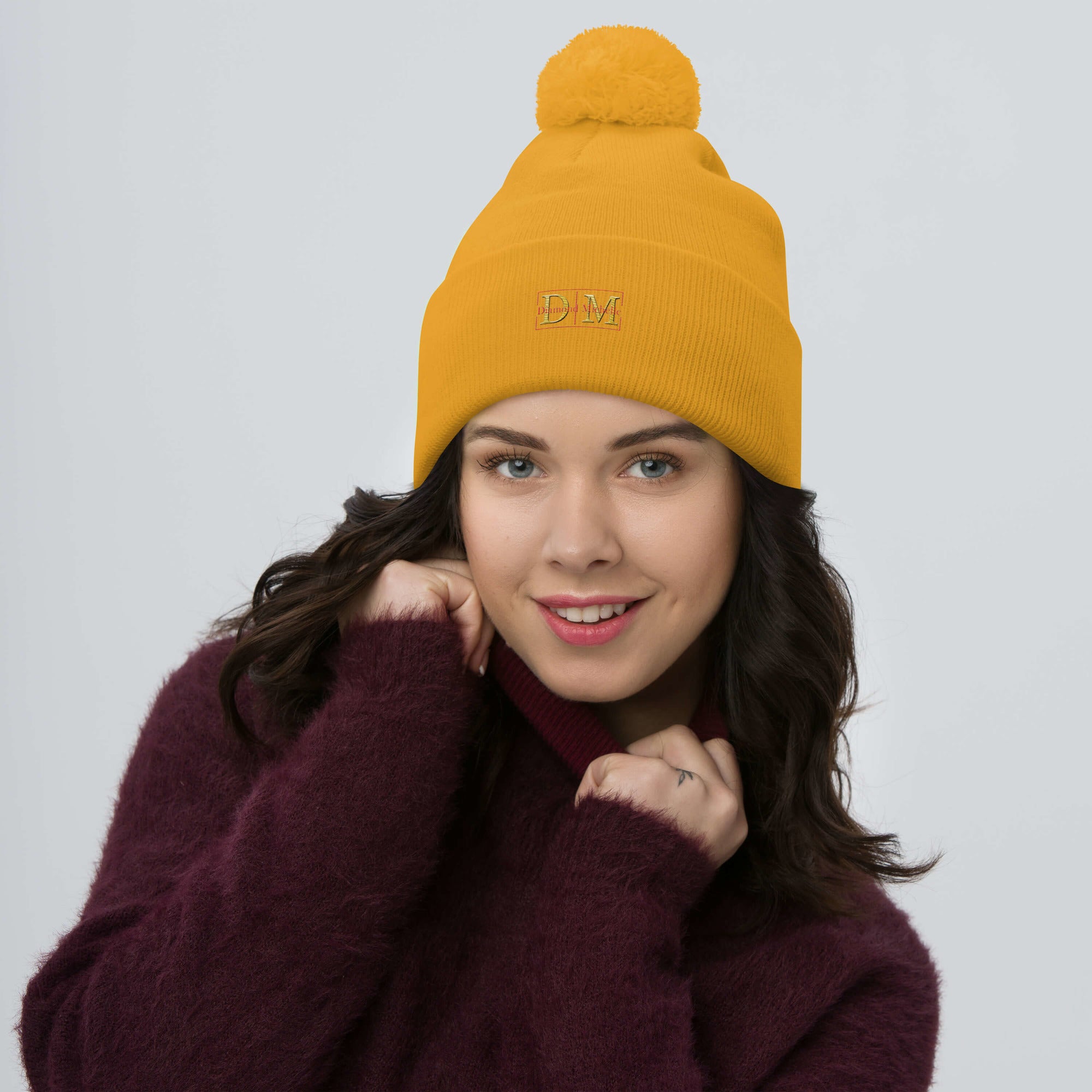 Woman wearing a gold DM Pom-Pom Beanie front view