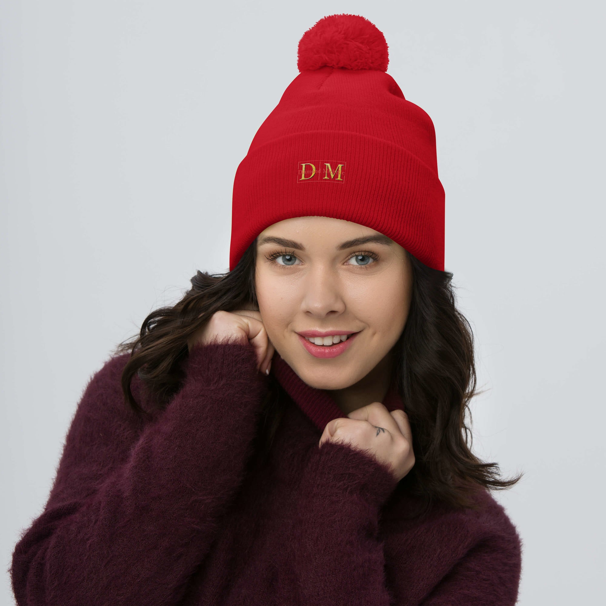 Woman wearing a red DM Pom-Pom Beanie front view