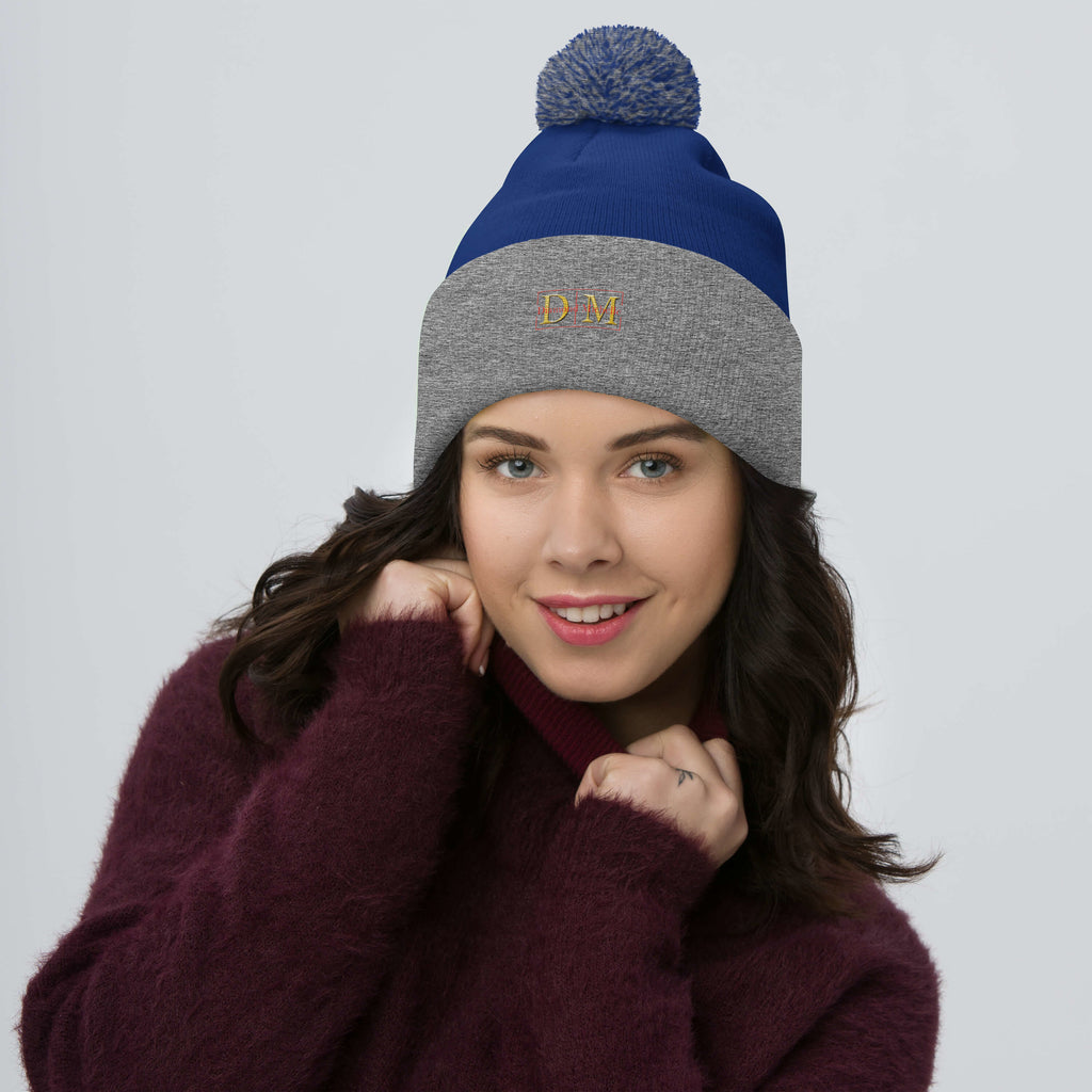 Woman wearing a royal blue and heather grey DM Pom-Pom Beanie front view