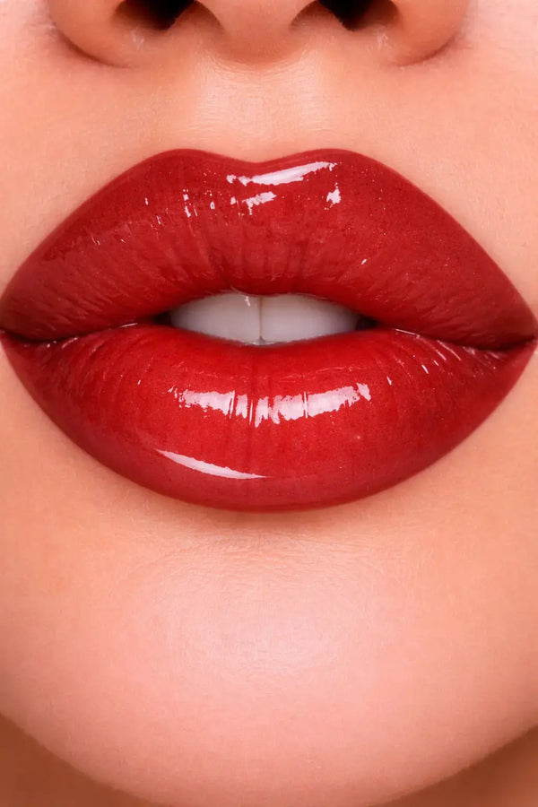 Close-up of glossy brick red lip gloss on lips