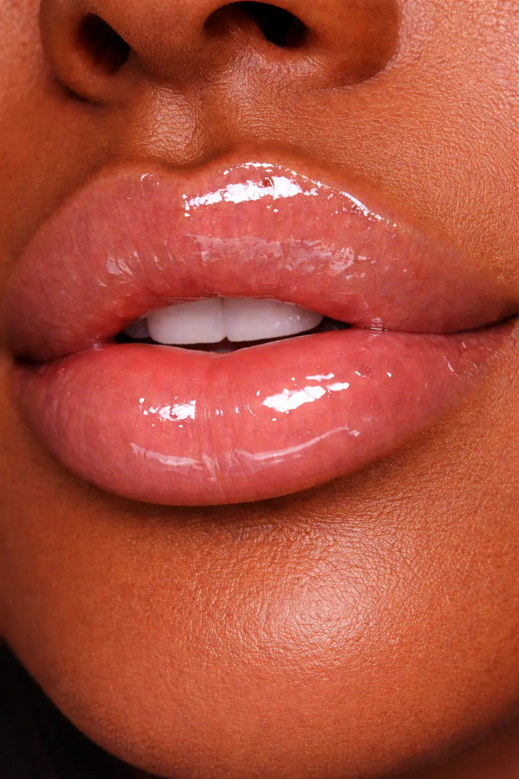 Close-up of glossy lips with a focus on texture and color wearing Diamond Glow Clear Lip Gloss.
